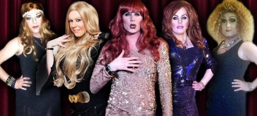 Five glamorous drag queens in elaborate outfits