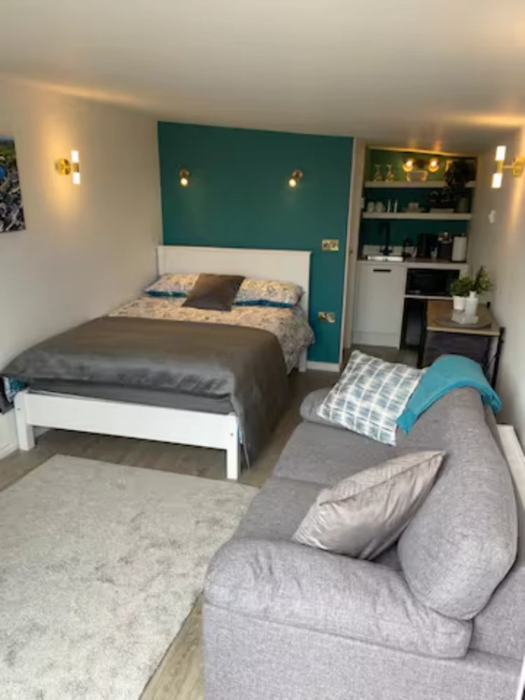 Stylish pod interior with bed, sofa, and kitchenette