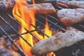 Sausages and meat sizzling on a BBQ grill